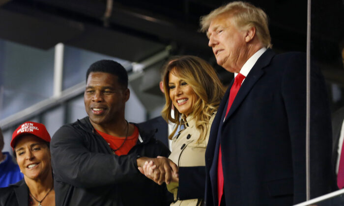 Former football player and political candidate Herschel Walker interacts with former U.S. President Donald Trump prior to Game Four of the World Series between the Houston Astros and the Atlanta Braves at Truist Park in Atlanta on Oct. 30, 2021. (Michael Zarrilli/Getty Images)