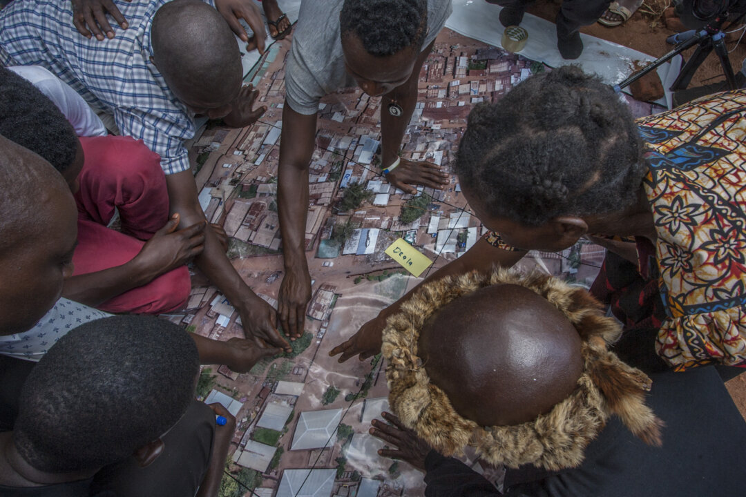 People look at an aerial map made using a drone camera during a drone mapping exercise for cholera hotspots organized and funded by UNICEF Malawi in Likuni, outside Lilongwe, Malawi, on Jan. 27, 2018. (Amos Gumulira/AFP via Getty Images)