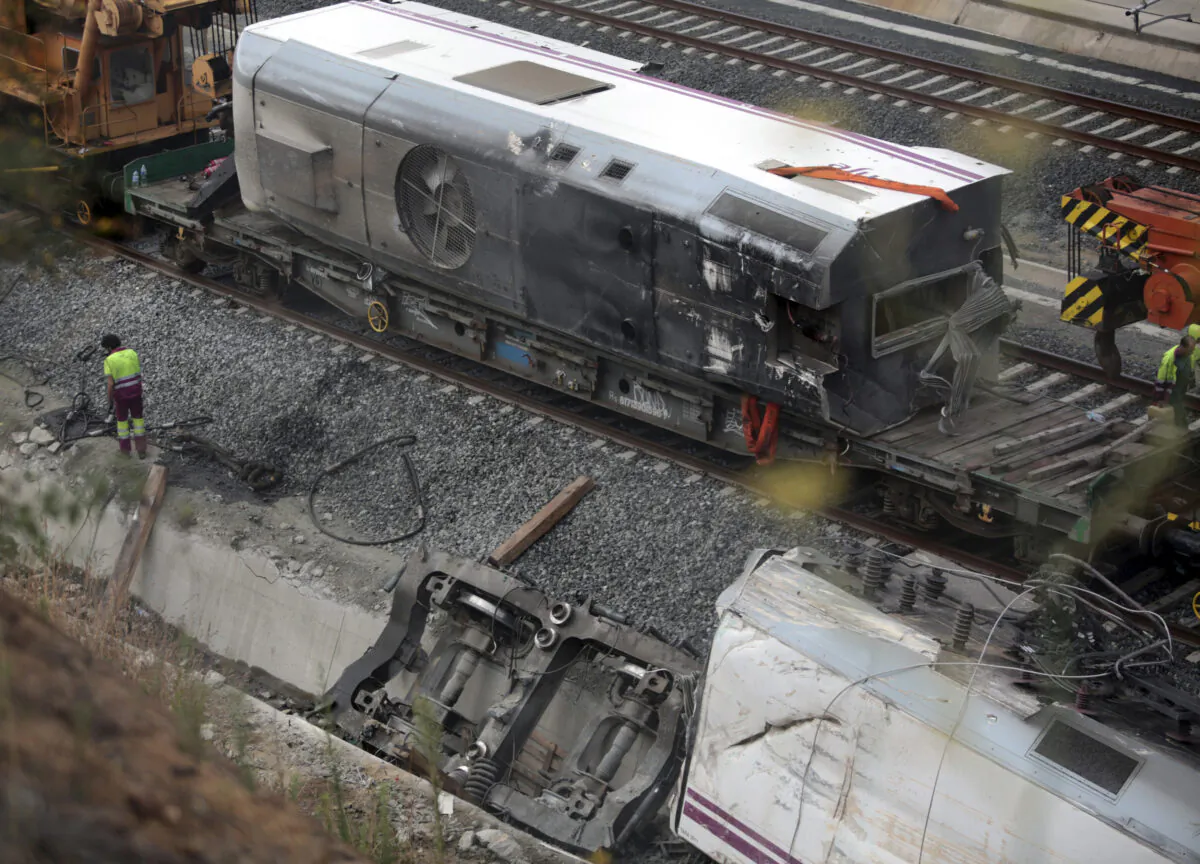 A worker stands beside the wrecked train engine (Bottom R) at the site of a train crash in Santiago de Compostela, northwestern Spain, on July 27, 2013. (Miguel Vidal/Reuters)