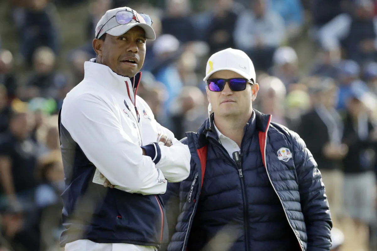 Tiger Woods (L) and then-United States team vice-captain Zach Johnson stand on the 8th green to watch a foursome match on the opening day of the 42nd Ryder Cup at Le Golf National in Saint-Quentin-en-Yvelines, outside Paris, on Sept. 28, 2018. (Matt Dunham/AP Photo)