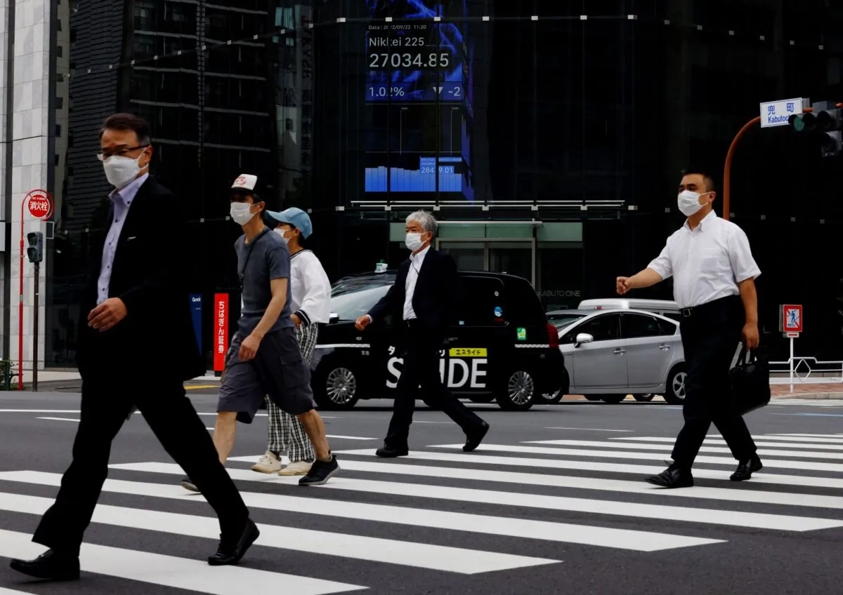 People pass by an electronic screen showing Japan's Nikkei share price index inside a commercial building in Tokyo, Japan, on Sept. 22, 2022. (Kim Kyung-Hoon/Reuters)
