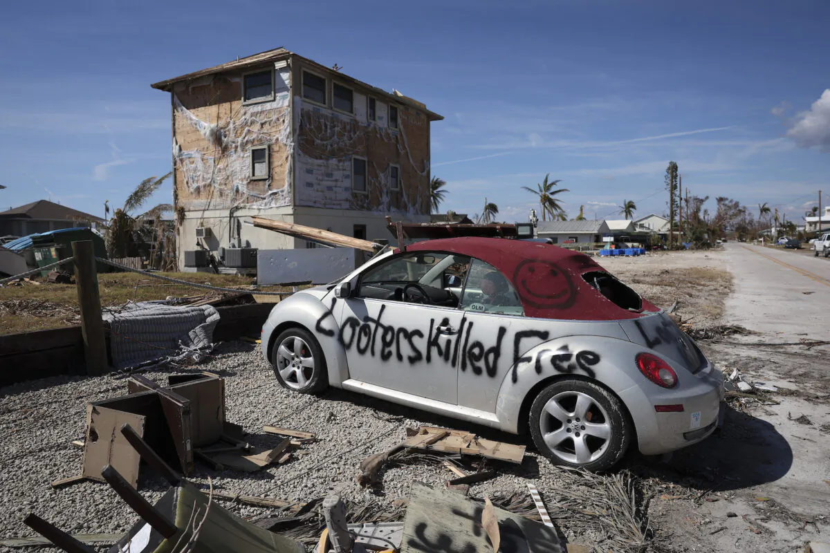 A warning to looters is painted on the side of a car destroyed during Hurricane Ian in Pine Island, Fla., on Oct. 3, 2022. (Win McNamee/Getty Images)