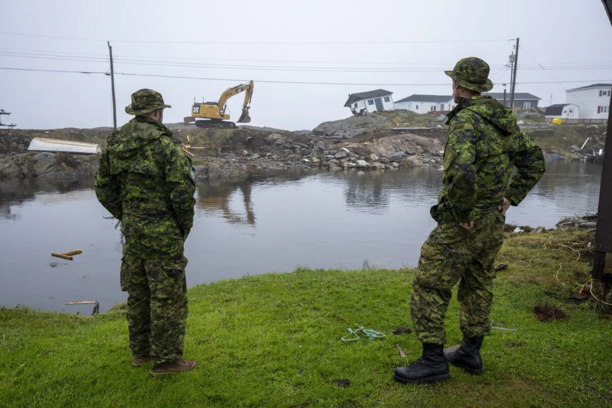 Canadian Armed Forces members from St John's survey the devastation left by post-tropical storm Fiona in Burnt Island, N.L., on Sept. 28, 2022. (The Canadian Press/Frank Gunn)