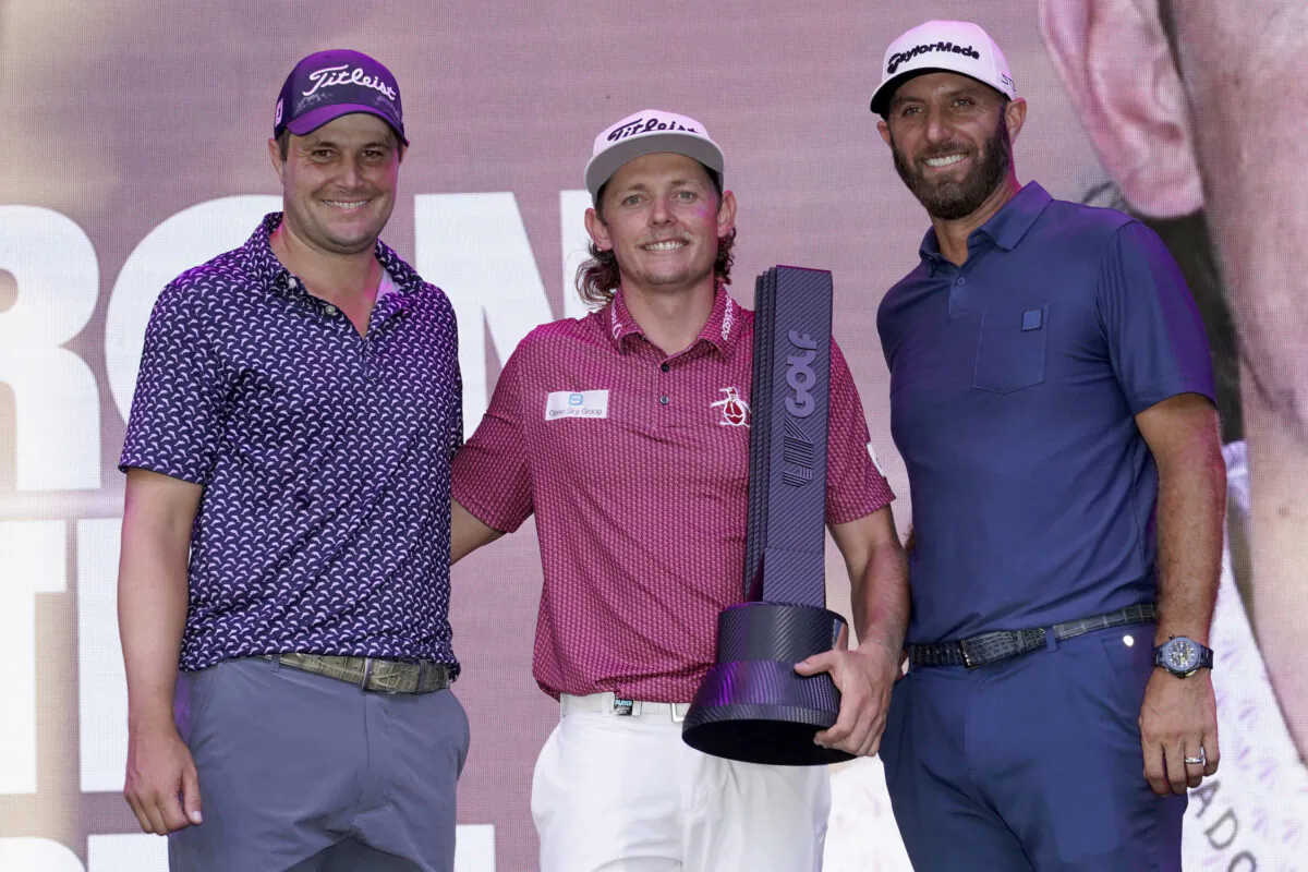 Cameron Smith winner of the LIV Golf Invitational-Chicago tournament stands with third place finisher Peter Uihlein, left, and second place finisher Dustin Johnson after the tournament  in Sugar Hill, Ill., Sept. 18, 2022. (Charles Rex Arbogast/AP Photo)