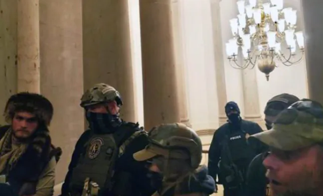 Oath Keepers face off with an angry crowd in front of U.S. Capitol Police officer Harry Dunn just before 3 p.m. on Jan. 6, 2021. (Kelly Meggs/Screenshot via The Epoch Times)