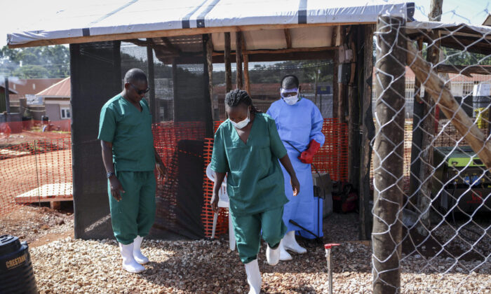 2022 年 9 月 29 日，一名医务人员在离开乌干达穆本德地区转诊医院的埃博拉隔离科之前对医务人员的橡胶靴进行消毒。（Hajarah Nalwadda/美联社照片）