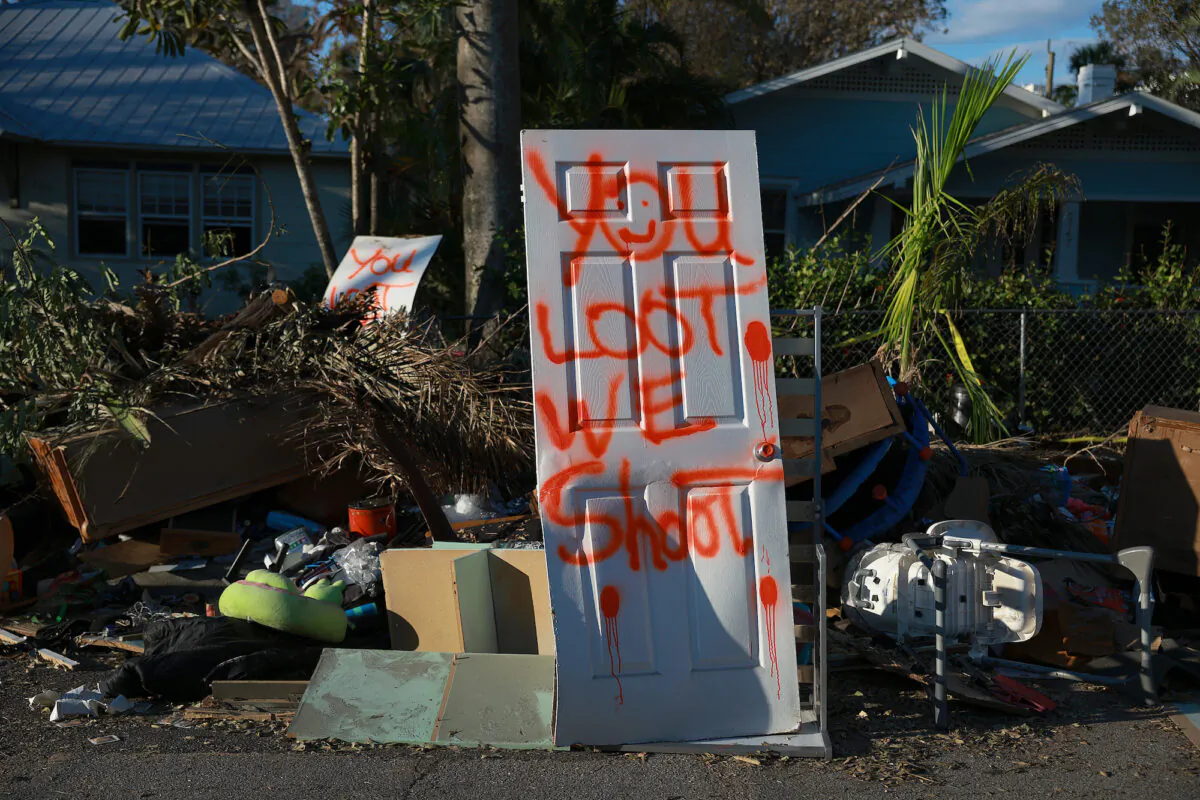A spray painted door reads 'you loot, we shoot' in Fort Myers, Fla., on Oct. 7, 2022. (Joe Raedle/Getty Images)