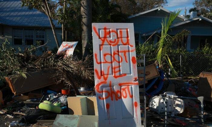 A spray painted door reads 'you loot, we shoot' in Fort Myers, Fla., on Oct. 7, 2022. (Joe Raedle/Getty Images)