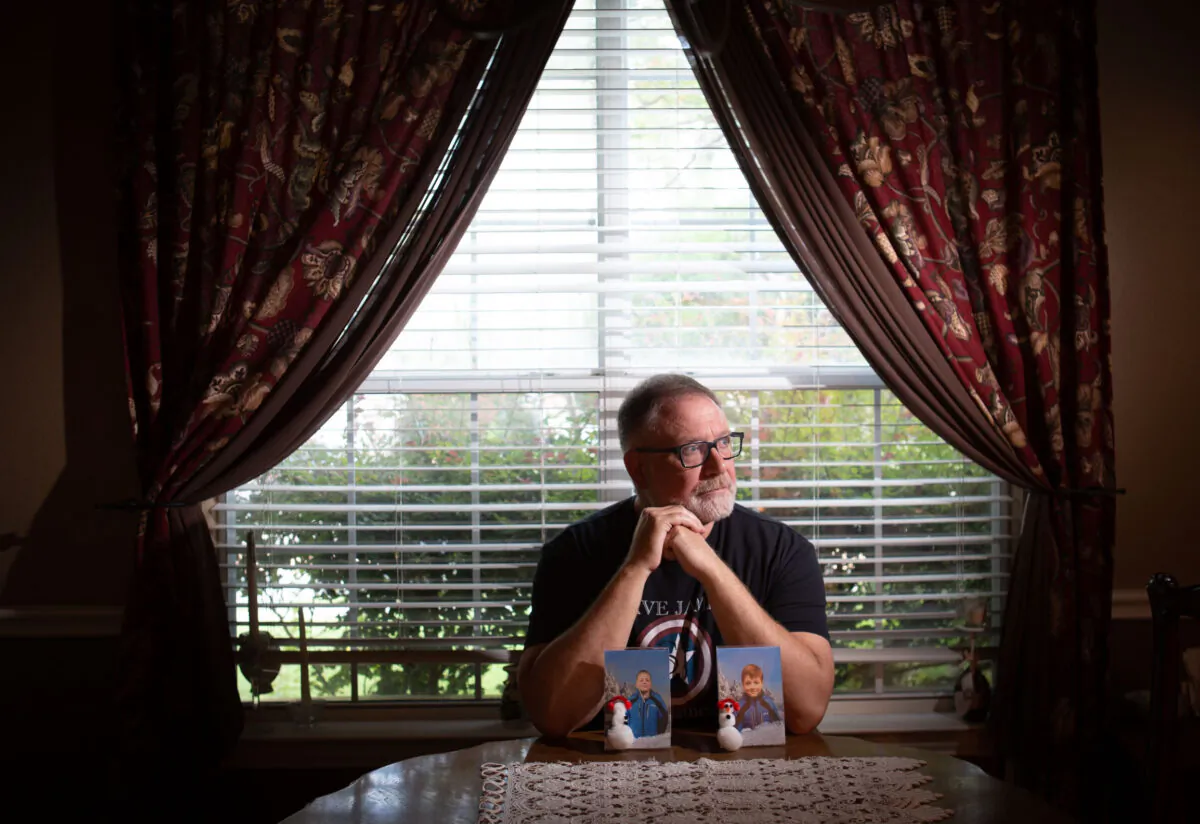 Jeff Younger sits alone behind photos of his twin boys at his North Texas home on September 16, 2022. (Bobby Sanchez for The Epoch Times)