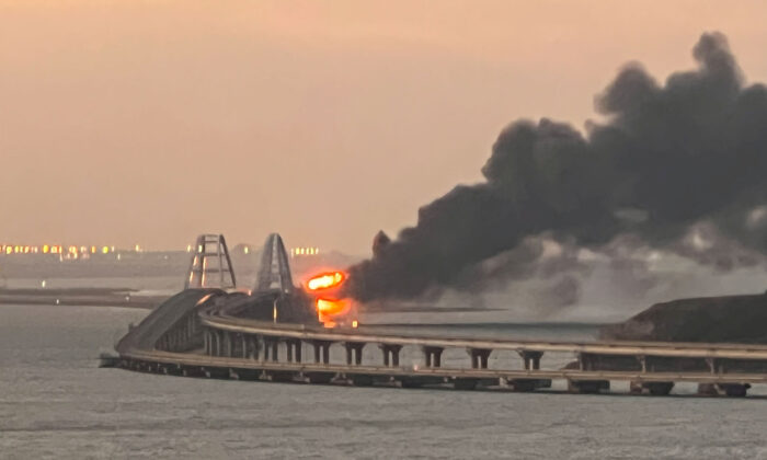 A view shows a fire on the Crimean Bridge, also called the Kerch bridge, at sunrise in the Kerch Strait, Crimea, Oct. 8, 2022. (Stringer/Reuters)