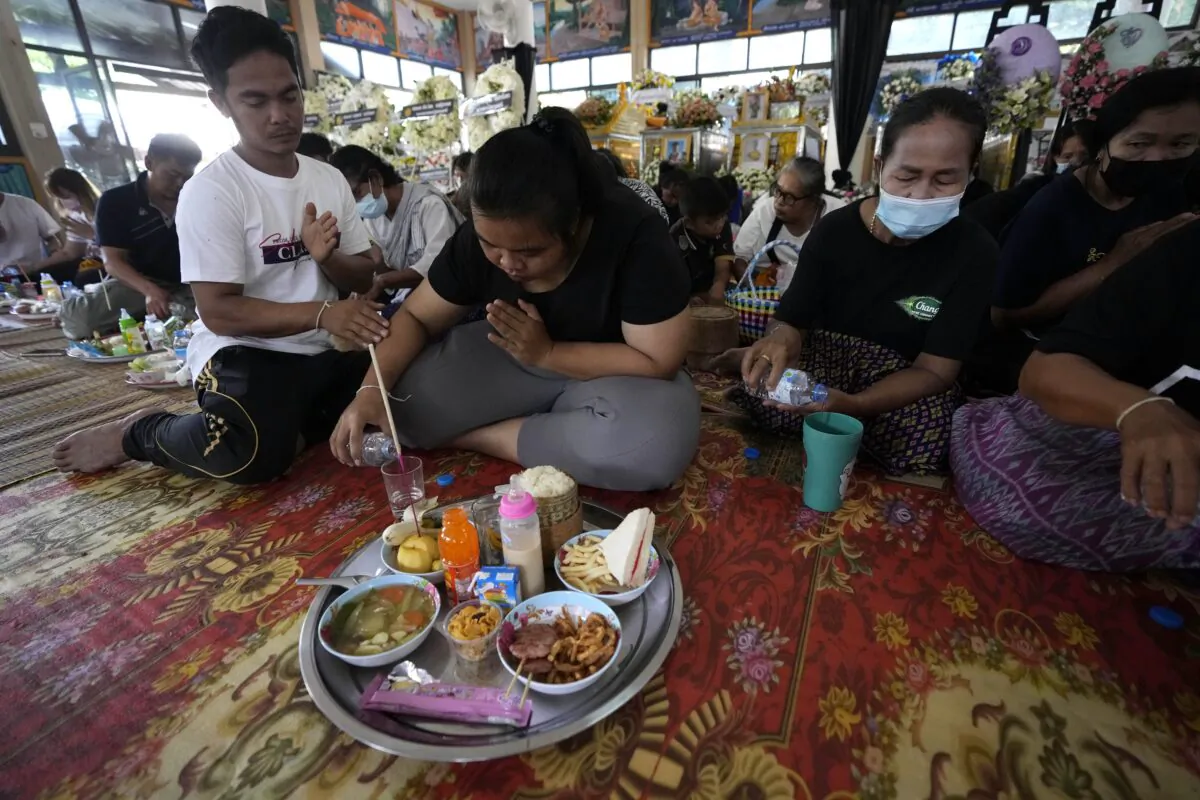 Relatives of the victims of a mass killing attack gather for a Buddhist ceremony inside Wat Rat Samakee temple in the rural town of Uthai Sawan, north eastern Thailand, on Oct. 9, 2022. (Sakchai Lalit/AP Photo)