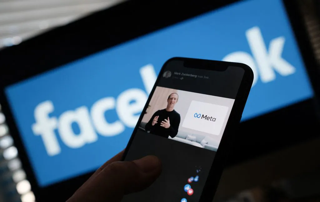 In this illustration photo taken in Los Angeles on Oct. 28, 2021, a person watches on a smartphone Facebook CEO Mark Zuckerberg unveil the META logo. (Chris Delmas/AFP via Getty Images)