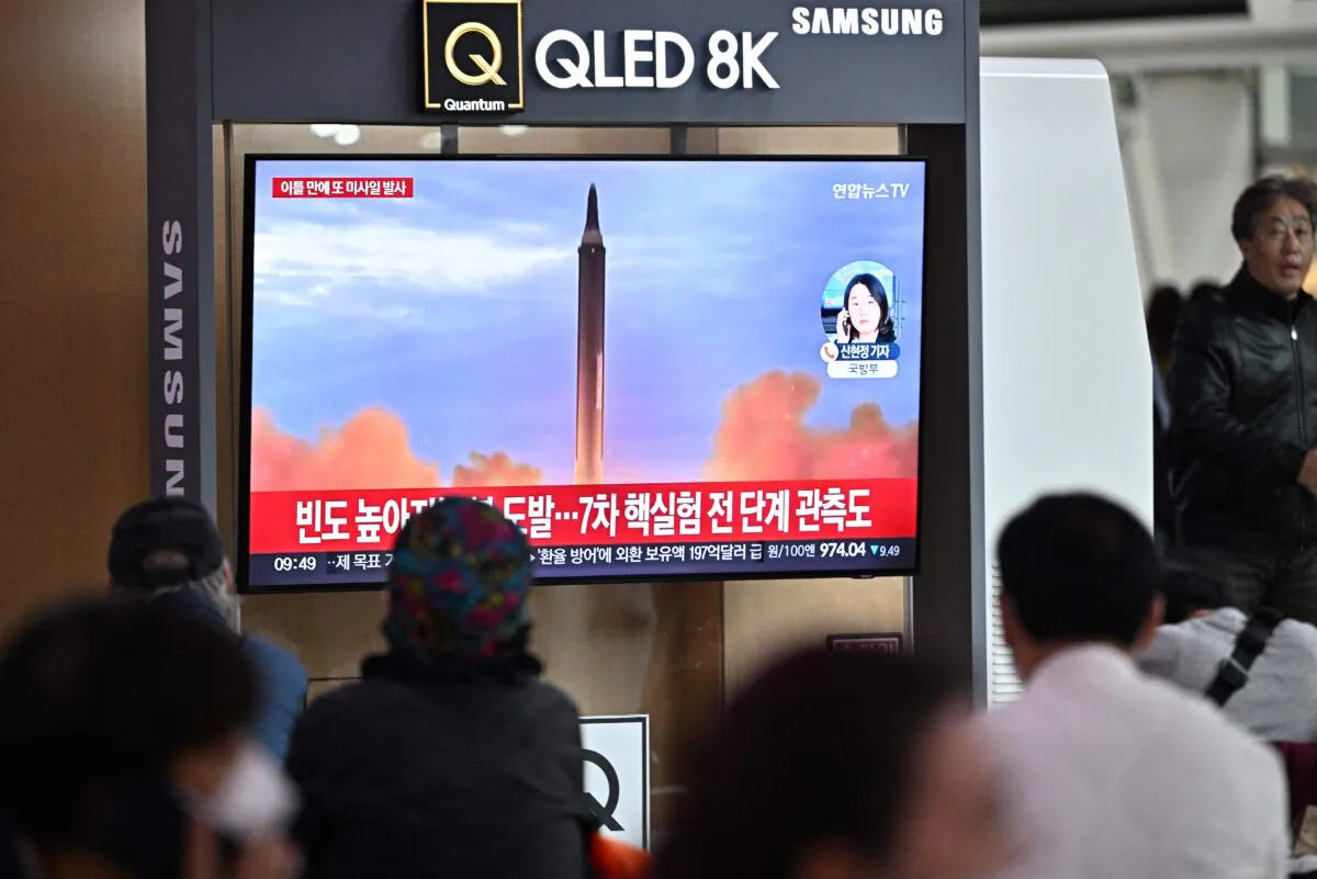 People sit near a television showing a news broadcast with file footage of a North Korean missile test, at a railway station in Seoul on Oct. 6, 2022. (Anthony Wallace/AFP via Getty Images)