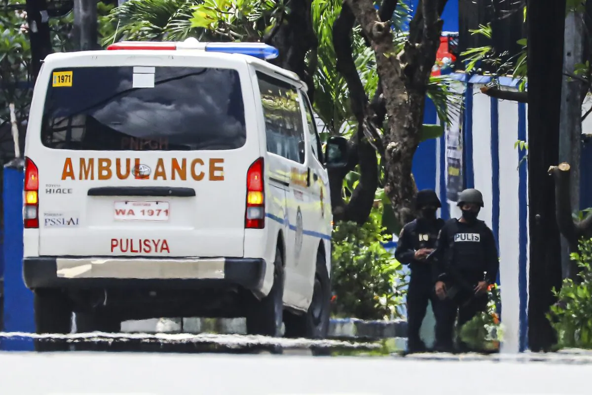 Police keep watch as an ambulance is parked outside the PNP Custodial Compound in Camp Crame police headquarters, Metro Manila, Philippines, on Oct. 9, 2022. (Gerard Carreon/AP Photo)