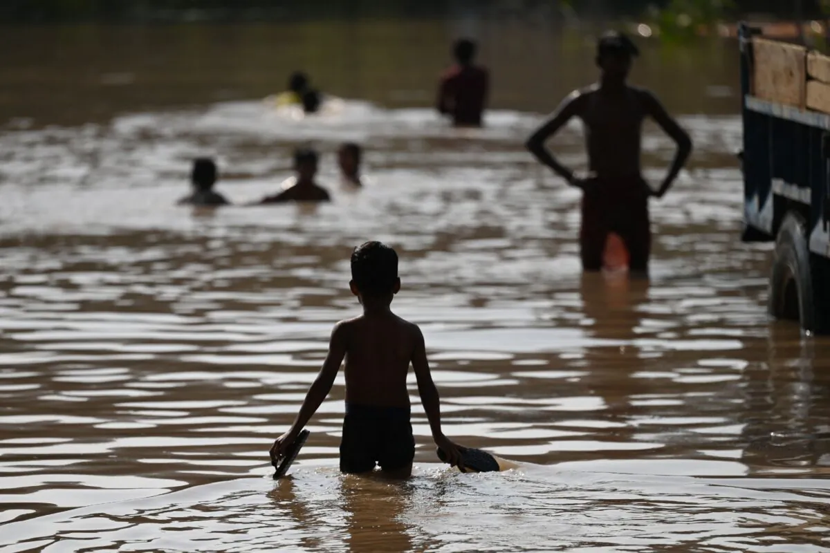 Children play in a flooded area after water levels of the Yamuna River increased due to recent rainfalls, in New Delhi on Sept. 28, 2022. (Sajjad Hussain/AFP via Getty Images)