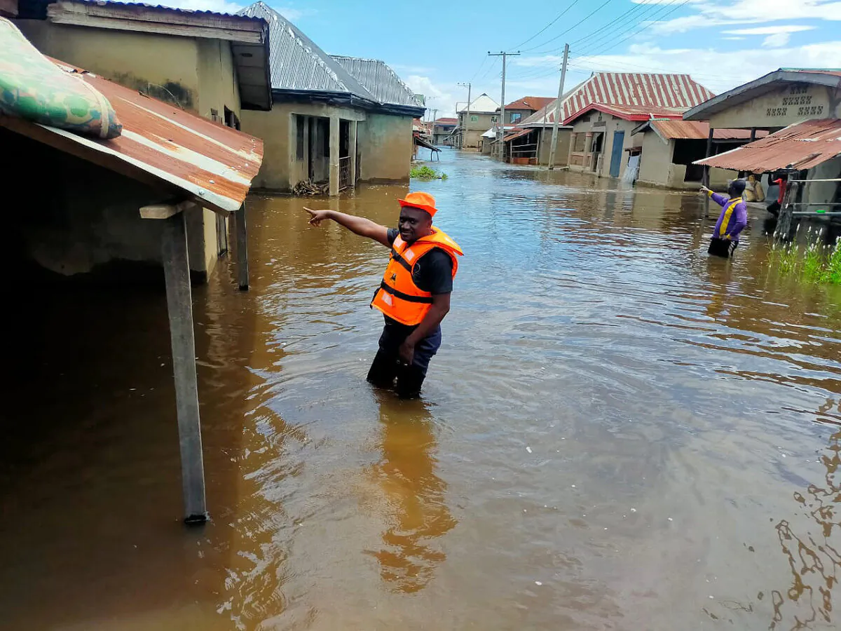 Rescued workers wade through a flooded street following a boat accident in Anambra, Nigeria, on Oct. 7, 2022. (National Emergency Management Agency via AP)