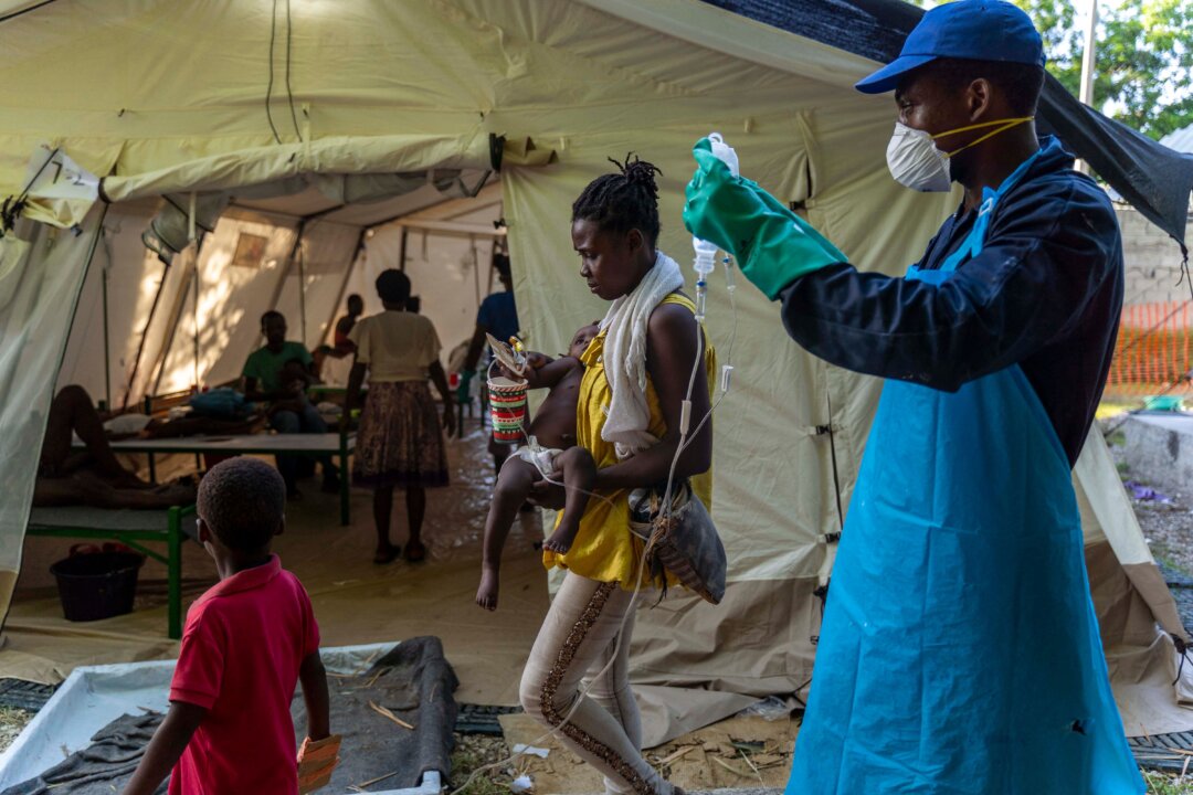 A woman brings her child showing symptoms of cholera to receive treatment at a clinic run by Doctors Without Borders in Cité Soleil a densely populated commune of Port-au-Prince, Haiti, on Oct. 7, 2022. (Richard Pierrin/AFP via Getty Images)
