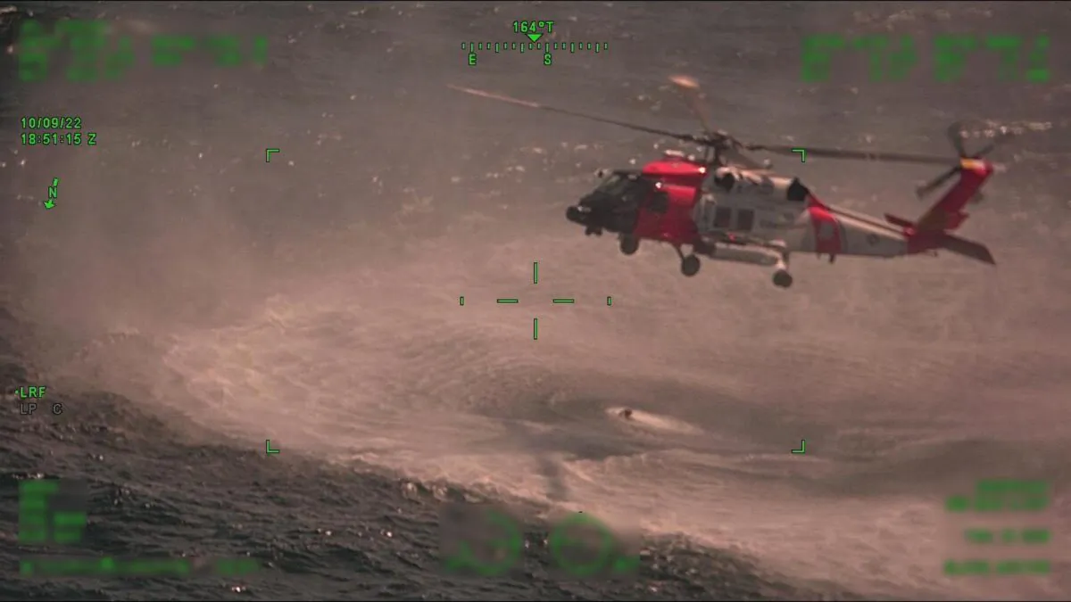 A Coast Guard Air Station New Orleans MH-60 Jayhawk hovers over their rescue swimmer during a rescue, approximately 25 miles offshore from Empire, La., on Oct. 9, 2022. (Coast Guard Air Station Corpus Christi)
