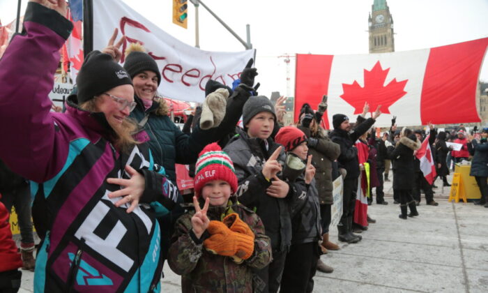 Families join the Freedom Convoy protest in downtown Ottawa after police distributed arrest notices to truckers and their supporters occupying Wellington St. and the Parliament Hill area on Feb. 16, 2022. (Richard Moore/The Epoch Times)