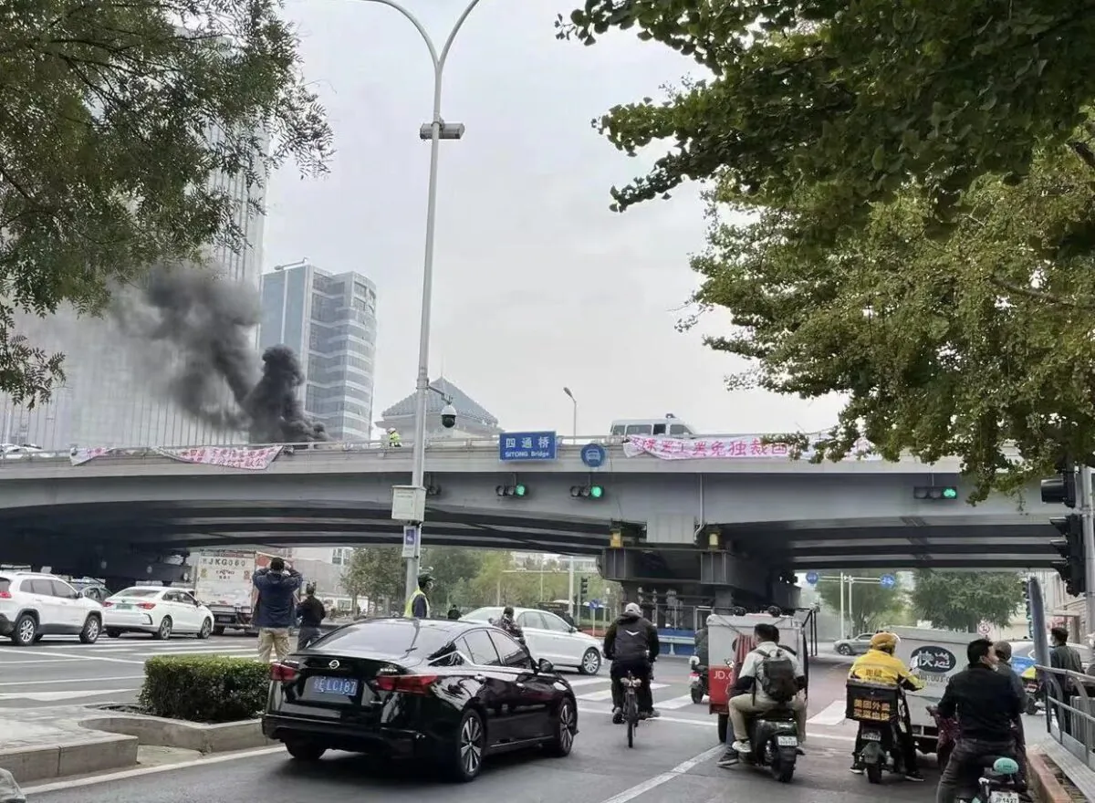 People take pictures of rare banners of political protest from an overpass in Beijing on Oct. 13, 2022.
(Screenshot of Fangshimin’s Twitter account via The Epoch Times)