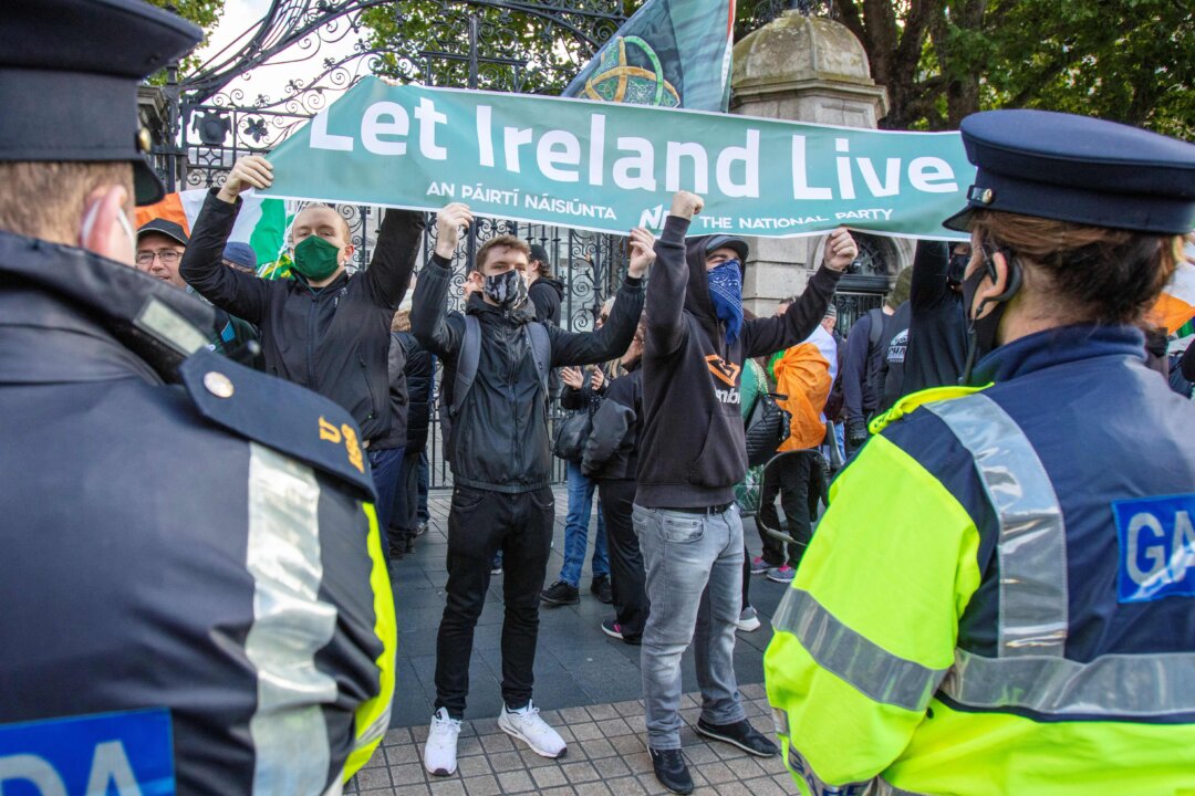 Anti-lockdown demonstrators hold a banner during a protest against outside Leinster House in Dublin on October 10, 2020. (Paul Faith/AFP via Getty Images)