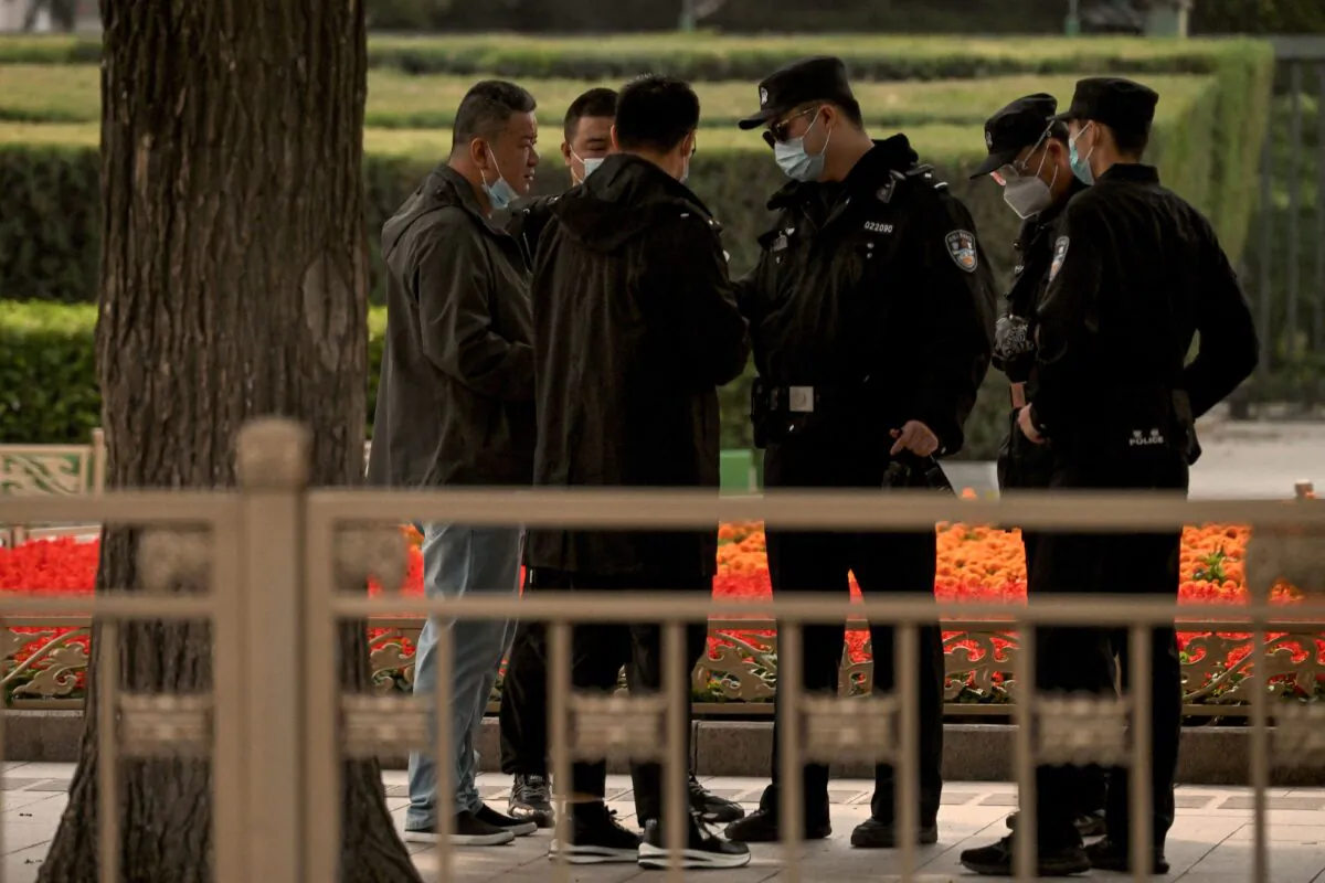 Police officers check the identification cards of people visiting Tiananmen Gate ahead of China's 20th Communist Party Congress in Beijing on October 13, 2022. (NOEL CELIS/AFP via Getty Images)