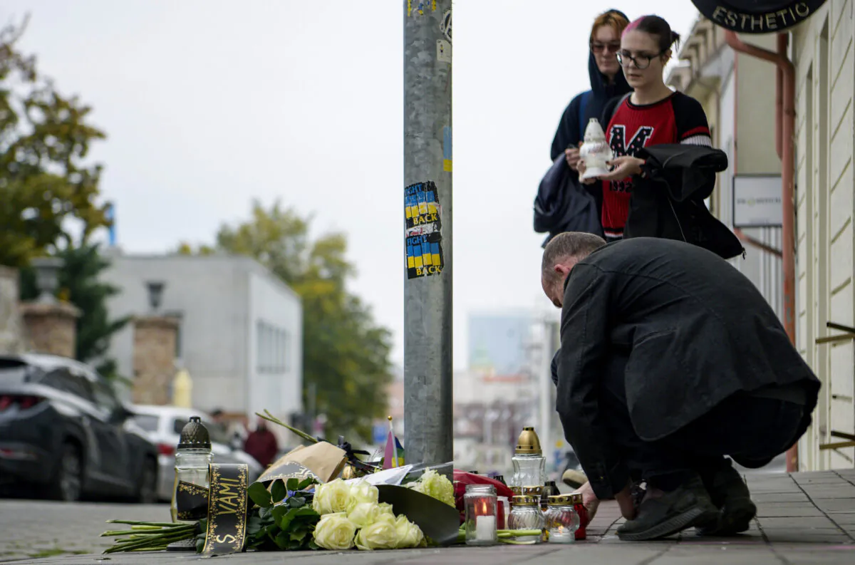 People lay flowers and light candles at the scene of Wednesday's attack on Zamocka Street in Bratislava, Slovakia, on Oct. 13, 2022. (Pavol Zachar/TASR via AP)