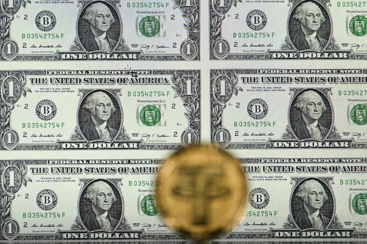 A gold-plated souvenir version of a Tether (USDT) coin arranged beside a screen displaying U.S. dollar notes, in an illustration picture taken in London on May 8, 2022. (Justin Tallis/AFP via Getty Images)