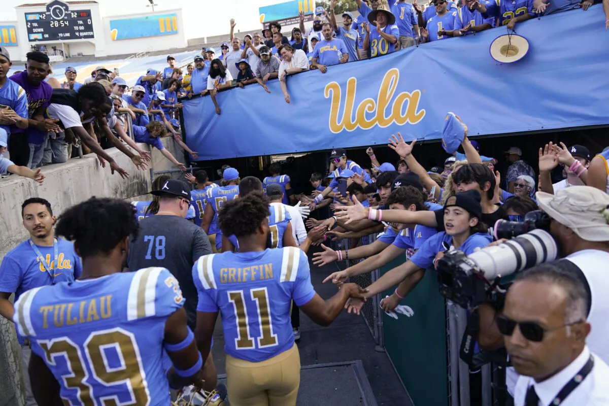 UCLA football players greet fans as they leave the field after a 42–32 win over Utah in an NCAA college football game in Pasadena, Calif., on Oct. 8, 2022. (Ashley Landis/AP Photo)