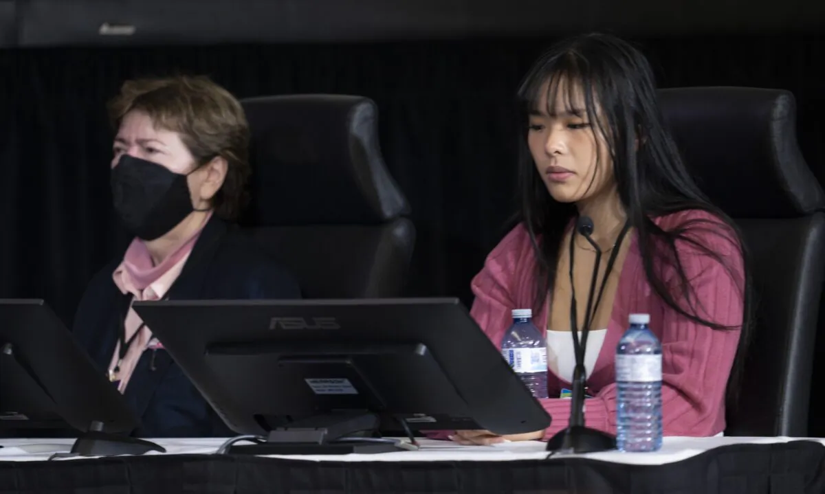 Victoria De La Ronde, left, and Zexi Li, the first witnesses to appear at the Public Order Emergency Commission, react as audio of truck horns from the protest is played during their testimony, in Ottawa, Friday, Oct. 14, 2022. (Adrian Wyld/The Canadian Press)