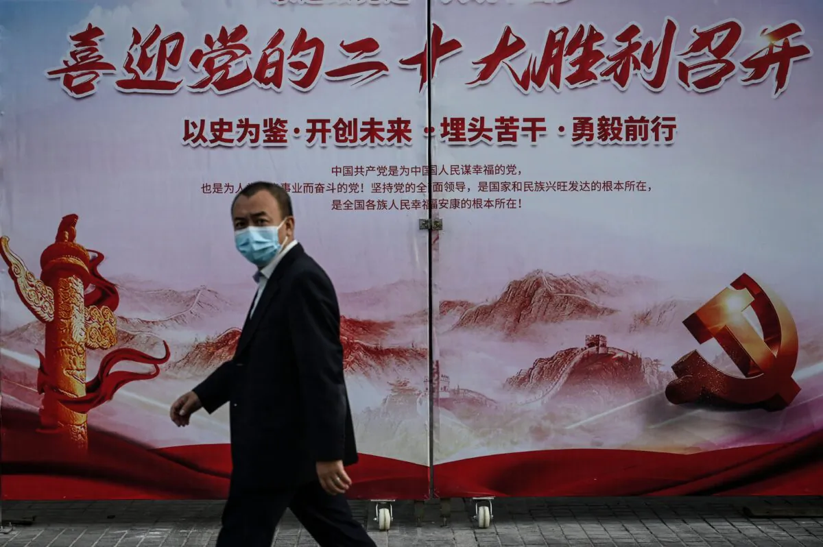 A man walks past a propaganda poster welcoming the  Communist Party's 20th National Congress on a street in Beijing, Sept. 21, 2022. (Jade Gao/AFP via Getty Images)
