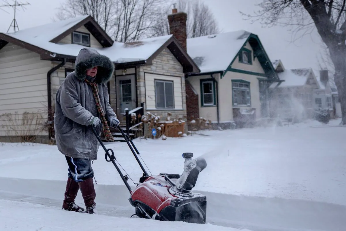 File photo showing a woman clearing the sidewalk during a heavy snowstorm in Saint Paul, Minn., on Feb. 22, 2022. (Kerem Yucel/AFP/Getty Images)