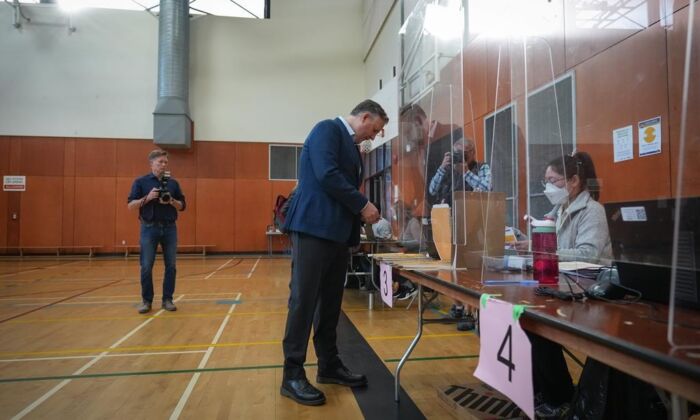 Vancouver mayoral candidate, incumbent Kennedy Stewart, picks up his civic election ballot from a polling station worker as he votes at an advance poll in Vancouver on Oct. 13, 2022.  (Darryl Dyck/The Canadian Press)