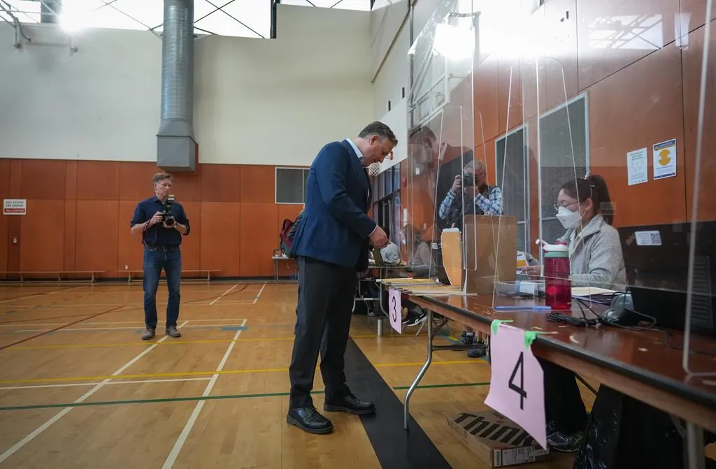 Vancouver mayoral candidate, incumbent Kennedy Stewart, picks up his civic election ballot from a polling station worker as he votes at an advance poll in Vancouver on Oct. 13, 2022.  (Darryl Dyck/The Canadian Press)