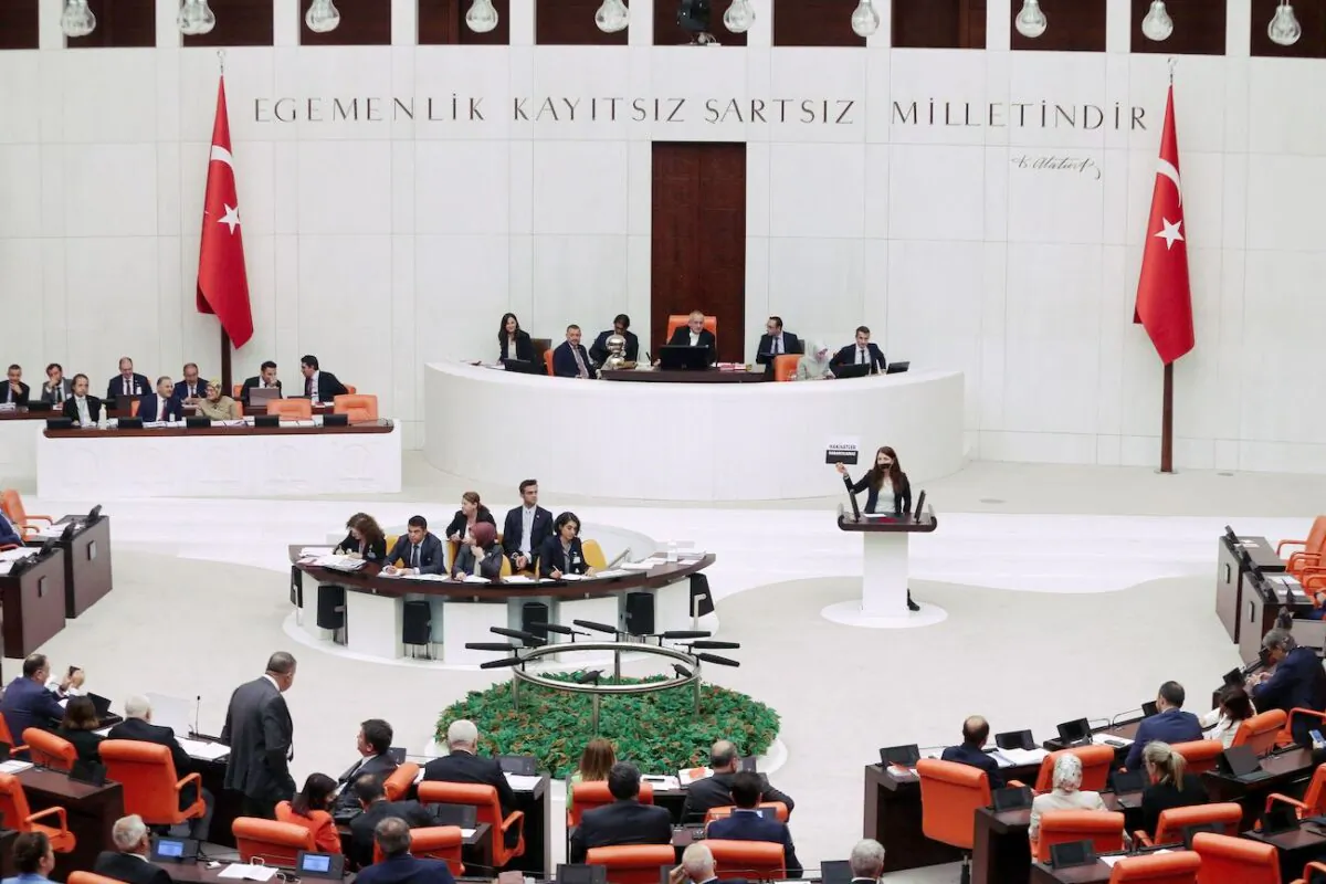 Peoples' Democratic Party's Zuleyha Gulum holds a banner "Truths cannot be obscured" as she stands with a covered mouth, in protest over a new media law that could lead to up to three years of jail for spreading "fake news" by reporters and social networks users, at the Turkish Grand National Assembly in Ankara, Turkey, on Oct. 13, 2022. (Adem Altan/AFP via Getty Images)