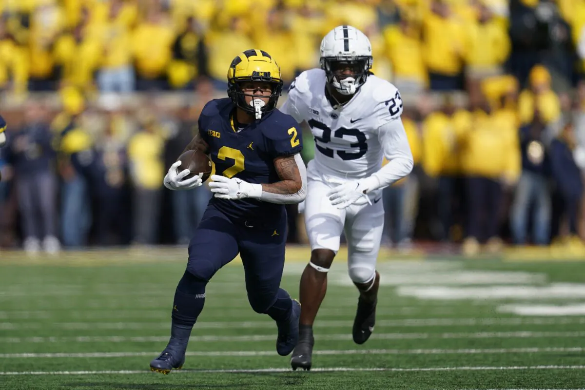 Michigan running back Blake Corum (2) runs the ball as Penn State linebacker Curtis Jacobs (23) chases in the first half of an NCAA college football game in Ann Arbor, Mich., on Oct. 15, 2022. (Paul Sancya/AP Photo)