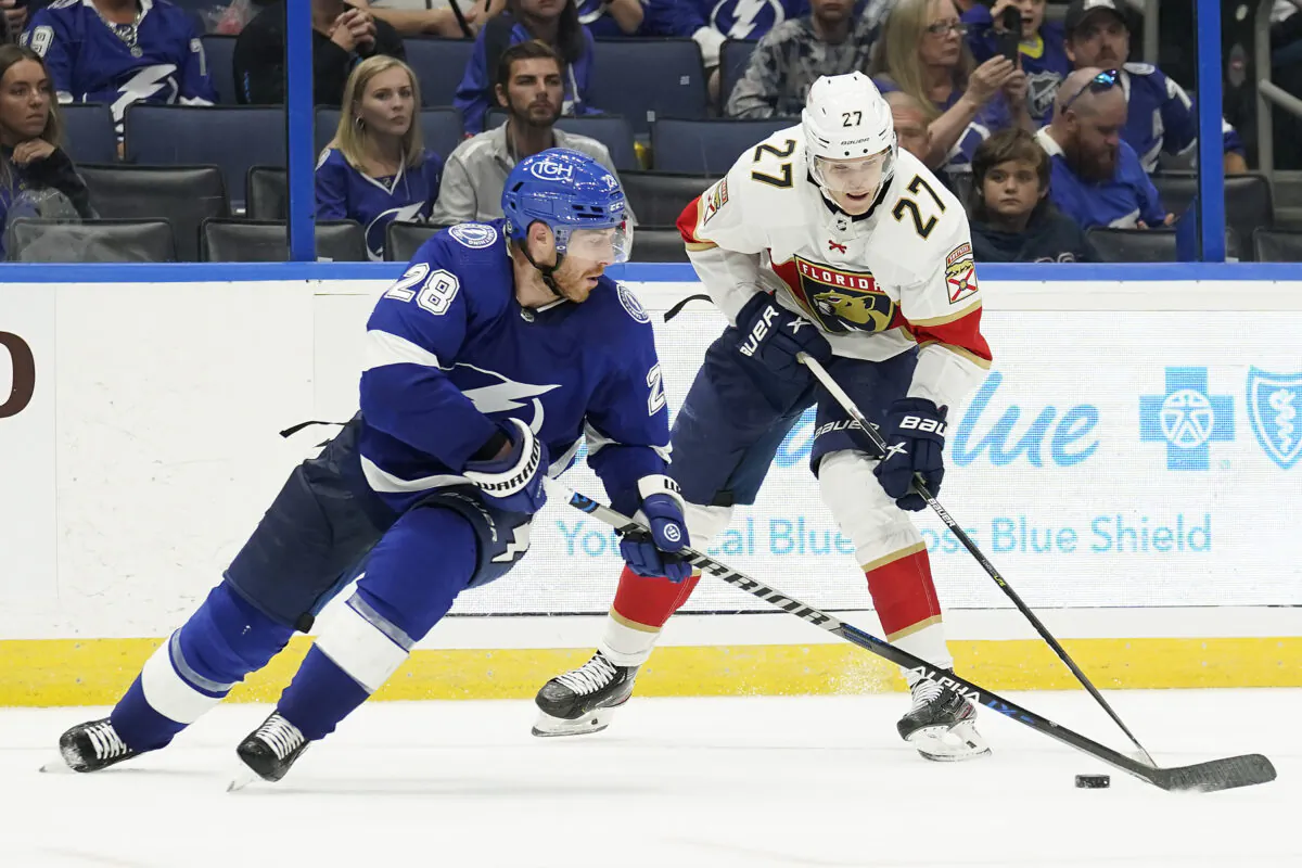 Florida Panthers center Eetu Luostarinen (27) works around Tampa Bay Lightning defenseman Ian Cole (28) during the third period of an NHL preseason hockey game in Tampa, Fla., on  Oct. 8, 2022. (Chris O'Meara/AP Photo)