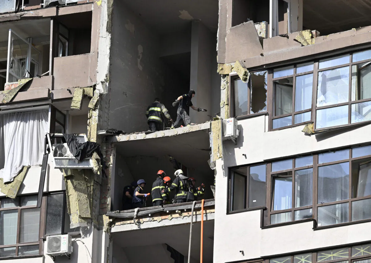 Rescuers and firefighters work in a damaged residential building, hit by Russian missiles in Kyiv on June 26, 2022, amid Russian invasion of Ukraine. (Genya Savilov/AFP via Getty Images)