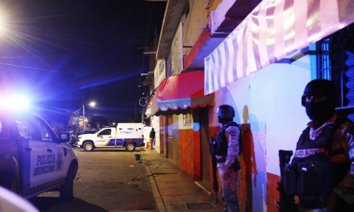 National Guard stands meters away from a bar where 12 people were killed by gunmen who opened fire on customers and staff in Irapuato, Guanajuato, Mexico, October 15, 2022.  (via Mario Armas/AFP Getty Images)