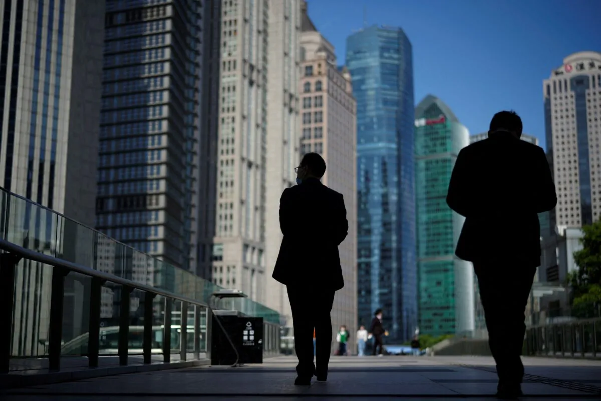 People walk by office towers in the Lujiazui financial district of Shanghai on Oct. 17, 2022. (Aly Song/Reuters)