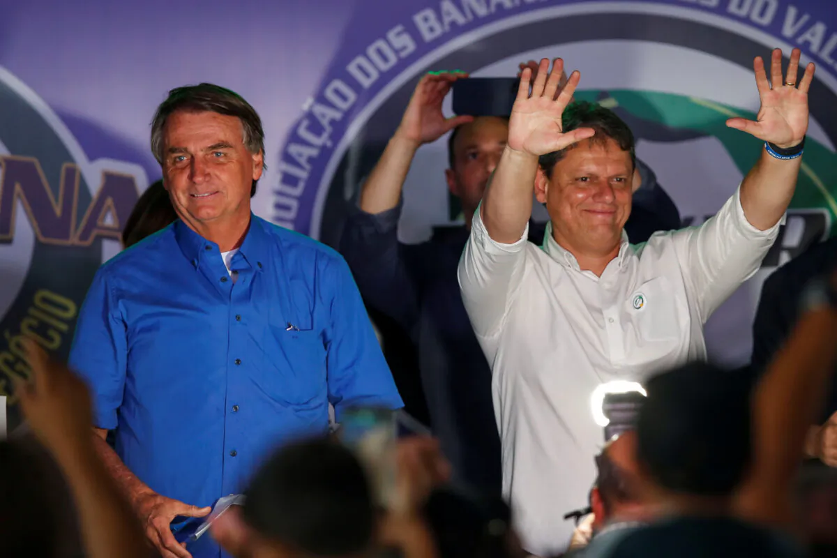 Former minister Tarcisio Freitas gestures next to Brazilian President Jair Bolsonaro (L) during a farmer's fair of banana producers in Pariquera-Acu, Sao Paulo state, Brazil, on May 12, 2022. (Amanda Perobelli/Reuters)