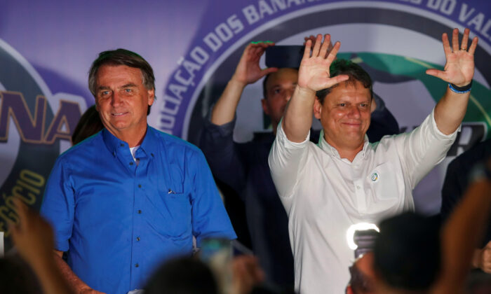 Były minister Tarcisio Freitas gestykuluje obok prezydenta Brazylii Jaira Bolsonaro (L) podczas targów producentów bananów w Pariquera-Acu, stan Sao Paulo, Brazylia, 12 maja 2022 r. (Amanda Perobelli/Reuters)