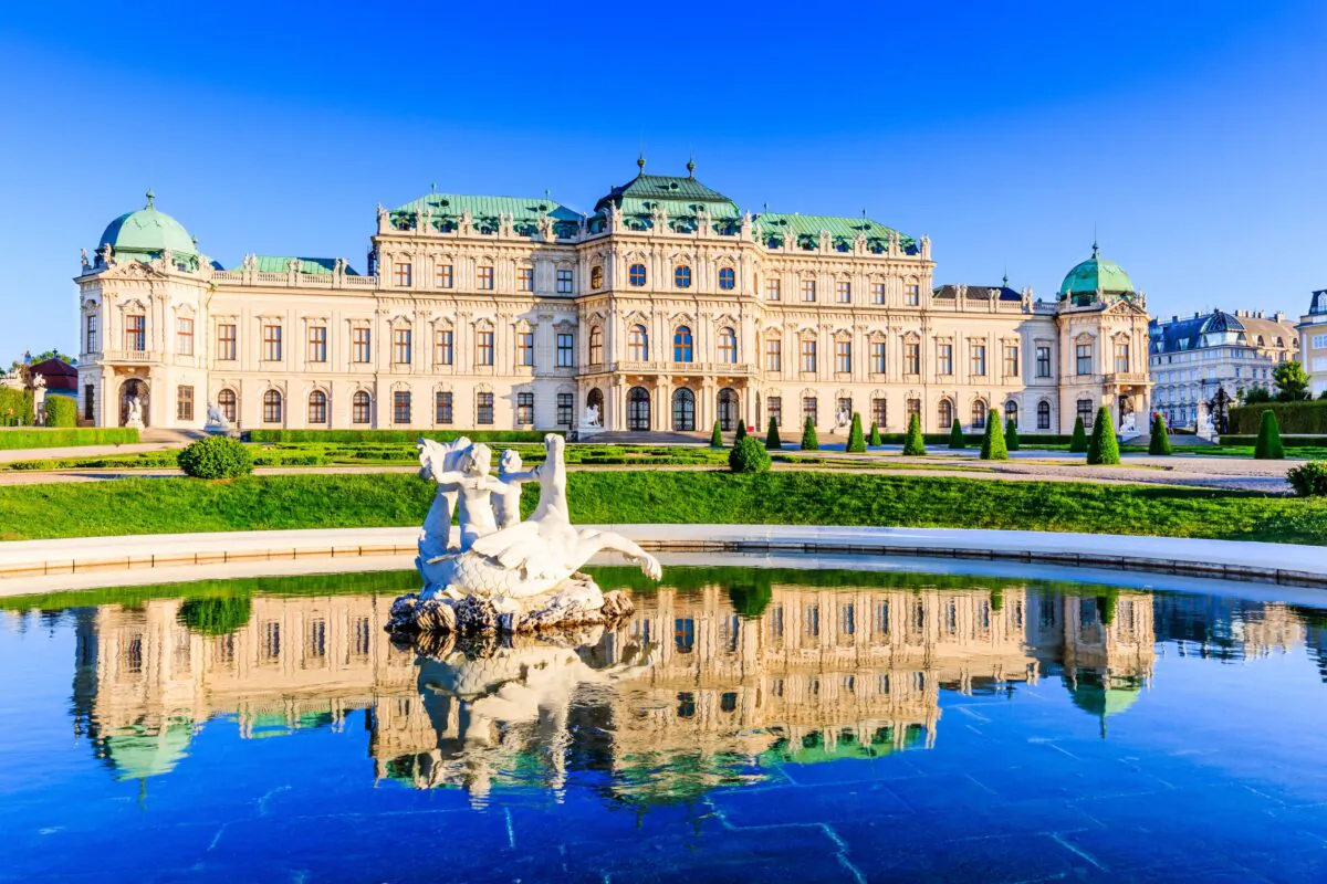 The Upper Belvedere palace in the center of Vienna, Austria, and its reflection in the water fountain. The building is composed of a long range of 29 bays, articulated as seven octagonal pavilions, with ornamented pilasters and window surrounds. These pavilions are in a typical 18th century French design, which can be seen in the Tuileries gardens (Paris) or at the Versailles palace. (SCstock/Shutterstock)