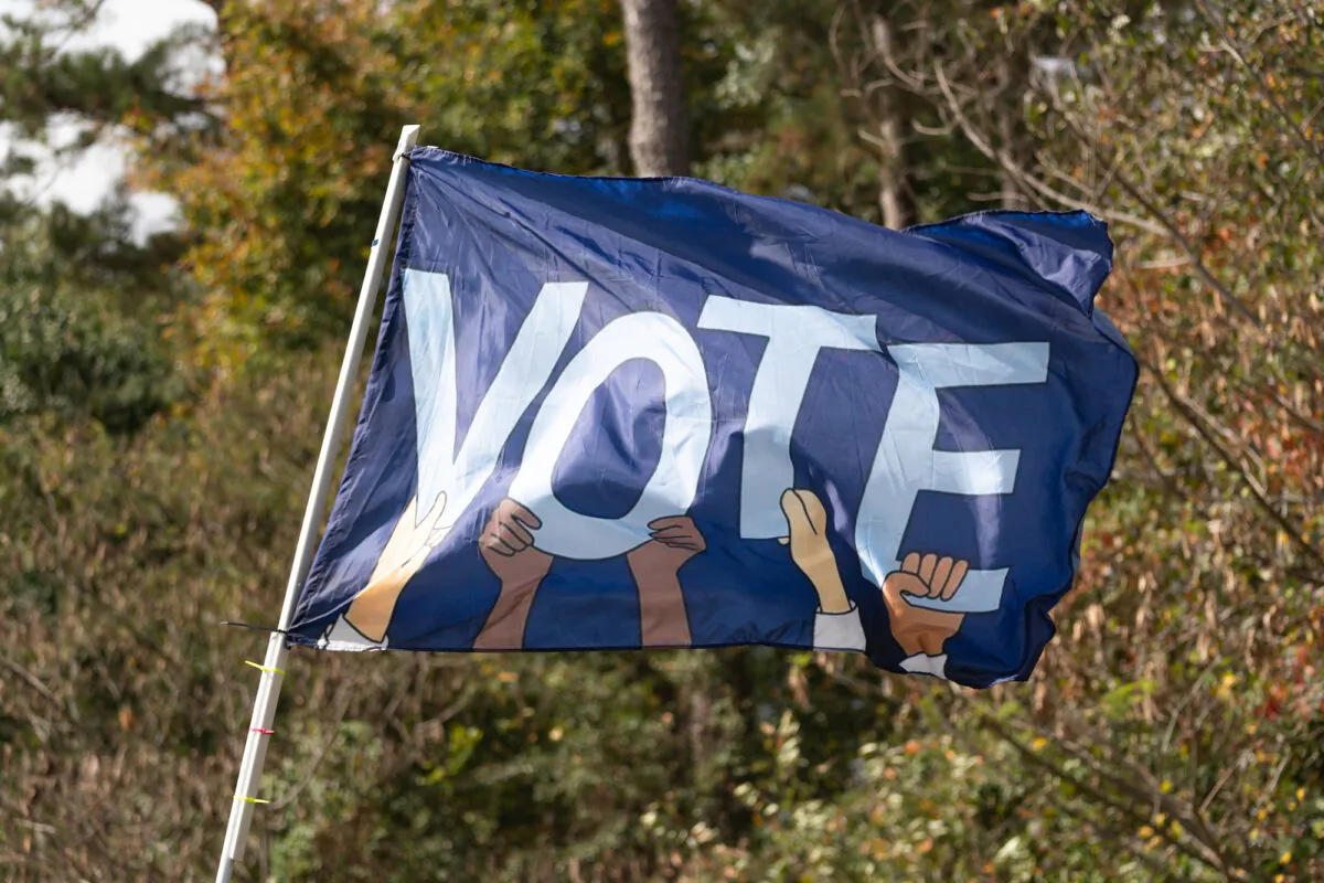 A flag reading VOTE waves as Sen. Raphael Warnock (D-Ga.) meets with community members to encourage them to come out and vote on the first day of early voting in Duluth, Ga., on Oct. 17, 2022. (Megan Varner/Getty Images)