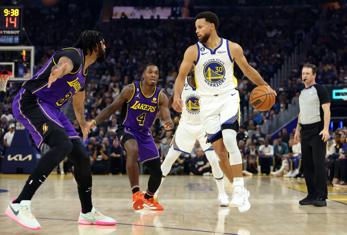 Stephen Curry (30) of the Golden State Warriors controls the ball as Lonnie Walker IV (4) and Anthony Davis (3) of the Los Angeles Lakers defend during the 1st half of the game at Chase Center in San Francisco, on October 18, 2022. (Ezra Shaw/Getty Images)