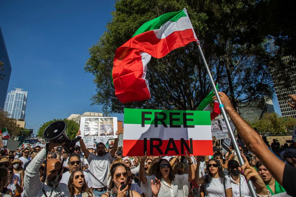 Demonstrators hold Iran's flag during a protest for Mahsa Amini who died in custody of Iran's morality police, in Los Angeles on Oct. 1, 2022. (Apu Gomes/AFP via Getty Images)