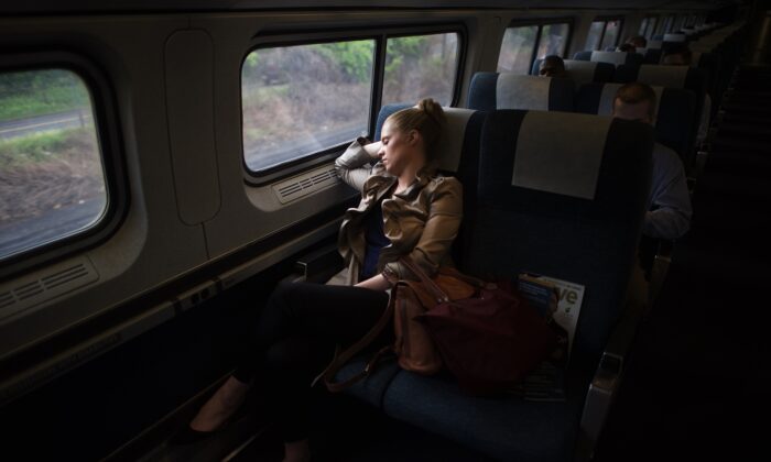 2015 年 5 月 18 日，一名乘客在宾夕法尼亚州费城第 30 街车站乘坐美铁列车时睡着了。（Mark Makela/Getty Images）