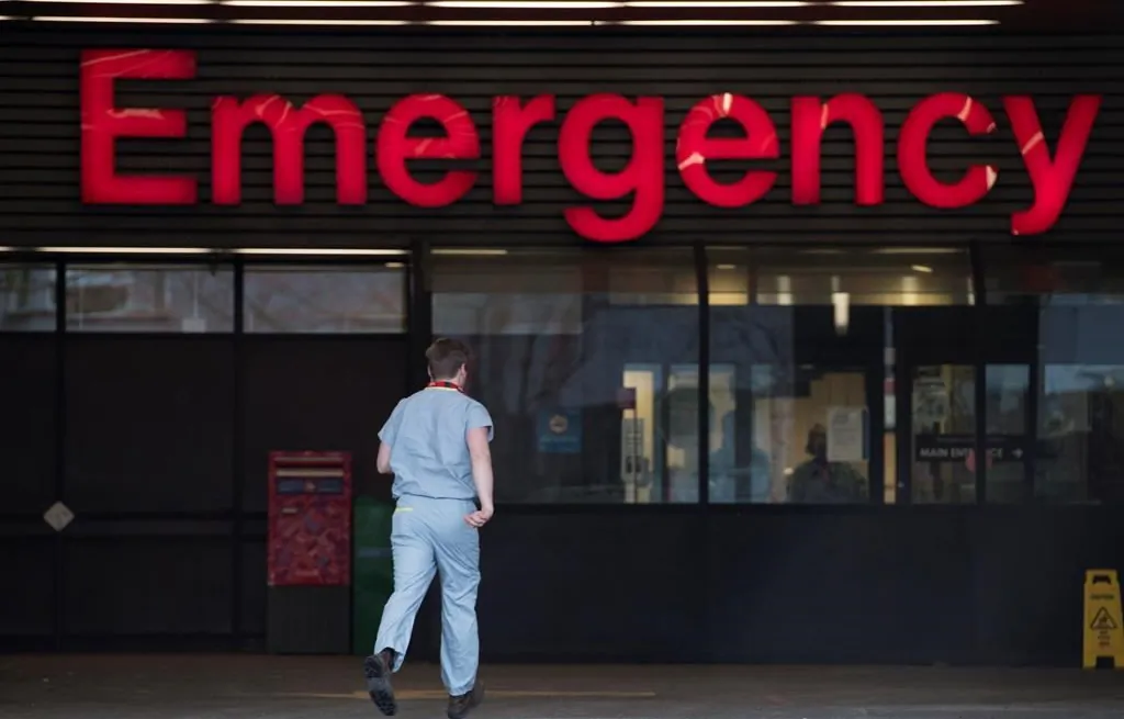 A health care worker makes his way into the Vancouver General Hospital emergency department. (Jonathan Hayward/The Canadian Press)