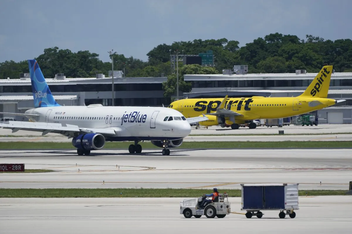 A JetBlue Airways Airbus A320 (L) passes a Spirit Airlines Airbus A320 as it taxis on the runway at the Fort Lauderdale-Hollywood International Airport in Fort Lauderdale, Fla., on July 7, 2022. (Wilfredo Lee/AP Photo)