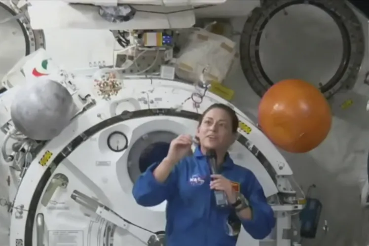Astronaut Nicole Mann shows her dream catcher during an interview on Oct. 19, 2022, in a still from video. (NASA via AP)